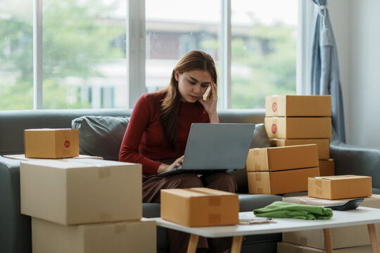 Young Woman Working At Small Business Ecommerce Using Laptop Stressed And Frustrated Surprised And Angry Face. Small Online Business Owner Woman Stressed Headache With Parcel Box At Home.