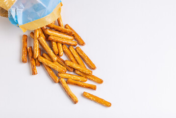 Top view of salty mini breadsticks on white spill out of packaging isolated on white background with copy space
