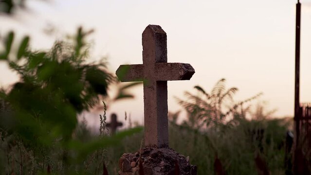 Scary silhouette of concrete cross against blue cloudy sky. Cemetery and murder, eternal memory of dead. Documentary chronicles of burial in film. perfectly straight cross in old cemetery.