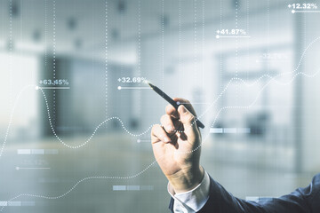Man hand with pen working with abstract virtual stats data hologram on blurred office background. Multiexposure