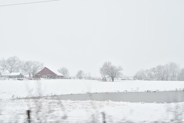 Barn and Pond in a Snowy Farm Field