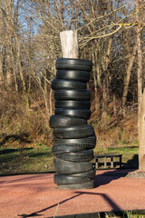 Tires from car wheels are like a punching bag on the training ground. Concept of reusing old rubber tires on an outdoor sports ground