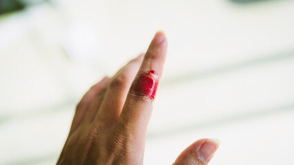 The hand of a person with a wound on the index finger and the bleeding does not stop even though it is covered with a plaster, concept of health insurance and accidents - obrazy, fototapety, plakaty