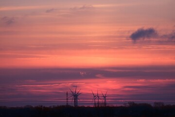 Naklejka premium Farm of electric windmills on background of colorful sunrise sky. Zulawy Gdanskie, Poland