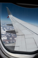 View of an airplane wing and clouds trough the window