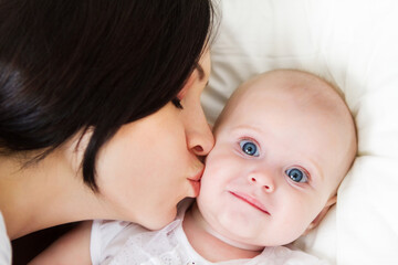 Happy smiling mother with six month old baby girl