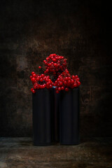 Still life with viburnum red in dark vases