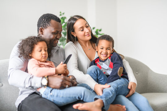 family with boy and girl child posing on photo shooting, sitting on couch