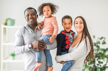 family with boy and girl child posing on photo shooting, in the living room