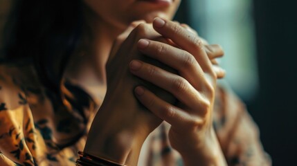 A close-up image of a person's hands held tightly together. This picture can be used to represent unity, teamwork, support, or prayer