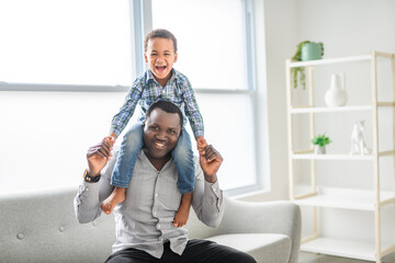 Happy Black American father with little boy at home