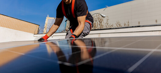 man placing a solar panel on the roof. renewable energy concept