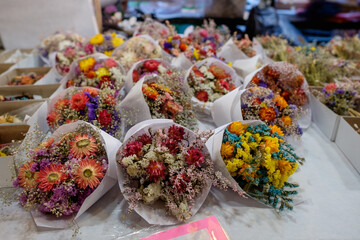 A floral display of mini flower arrangements at a farmer market