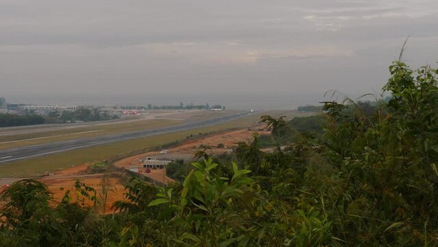 Panoramic view of airport airfield on tropical island. Long shot aircraft speed up and take off. Airliner on the runway. Flight departure.