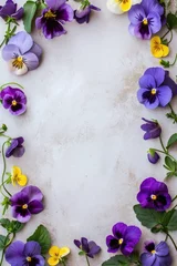 Tuinposter Purple and yellow pansies border on a marble background. Flat lay composition with copy space. Floral design and spring concept. Design for greeting card, invitation, poster. Springtime beauty © dreamdes