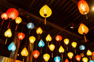 Glowing paper lanterns decorating room in Asian style.