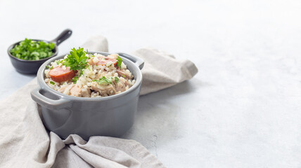 Chicken bog dish with smocked sausages, in small pot, horizontal, copy space