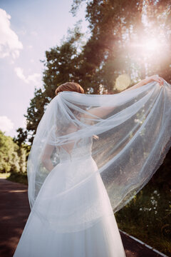 The image features a woman wearing a white wedding dress standing outdoors with a tree in the background. 5315