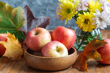 Autumn season or Thanksgiving holiday concept with apples, flowers and fall leaves, horizontal