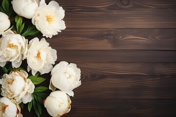 Flat lay of white peony flowers with copyspace on wooden background