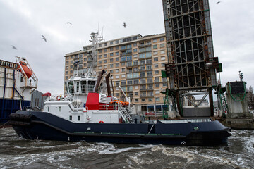 Tugboat, cargo ship and drawbridge in the port of Saint-Nazaire in Brittany, France