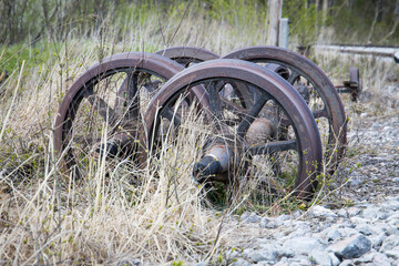 Steel wheels of an old steam locomotive rotting in the grass