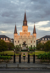 Fototapeta premium Rays from rising sun hit the facade of the Cathedral of St Louis, King of France with statue of Andrew Jackson in New Orleans in Louisiana