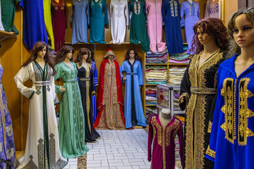 Morocco, row of typical colourful womens embroidered djellaba tunics for sale.