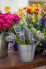A bouquets of spring flowers in a tin buckets in a flower shop.