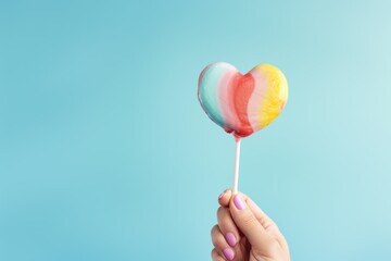 Colorful lollipop in shape of heart on blue background - Powered by Adobe