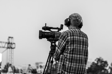elderly man videographer films on camera in summer