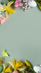 Spring flowers ans easter eggs border on green background with copy space. Easter greeting card template