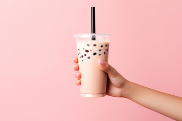 a hand holding a cup of bubble tea