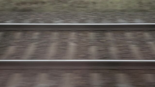 Rails on railway is blurred horizontally in motion.