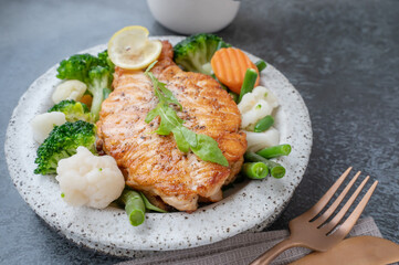 Salmon steak with vegetables cauliflower, broccoli, carrots and green beans. Salad of arugula and vegetables with salmon.
