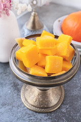 Homemade pumpkin and agar-agar gummies. Orange jelly candies served on a plate with pumpkin in the background. Close-up