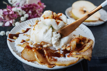 burrata is served with roasted caramelized pear and pine nuts. Close-up