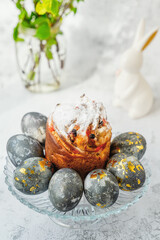 Easter kulich, bunnies and eggs with golden pattern. A plate with kraffin, Easter eggs and bunnies. The concept of home comfort in the bright holiday of Easter