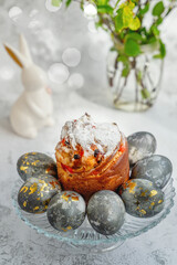 Easter kulich, bunnies and eggs with golden pattern. A plate with kraffin, Easter eggs and bunnies. The concept of home comfort in the bright holiday of Easter