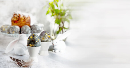 Banner. Easter eggs with gold pattern. A plate with Easter eggs and bunny figures. The concept of...