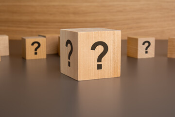 wooden cube questions signs on its sides. concept of choosing the right solution