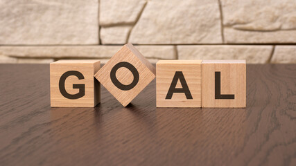Fototapeta premium word GOAL block wood on wooden table background. GOAL business concept.