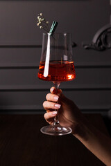 the girl's hand holds a glass with a red drink in the bar and in the restaurant