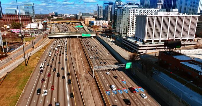 Multiple vehicles moving by the wide roads of Atlanta, Georgia, USA. Top view on city downtown on sunny daytime.