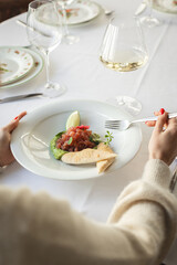 Salmon tartare, avocado. Large white plate, restaurant serving food. Food photo.