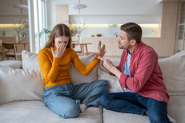 Nervous aggressive emotional husband threatening helpless unhappy wife. Stressed female crying,...
