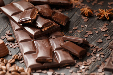 Dark chocolate and spices on wooden background
