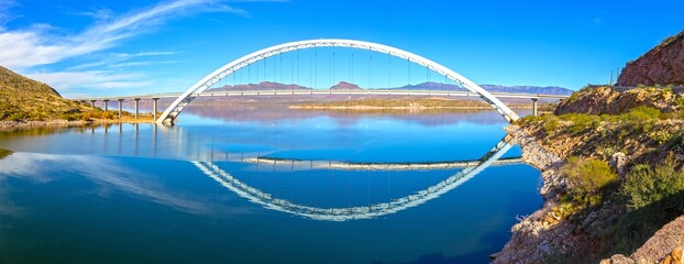 Roosevelt Bridge Arch Ellipse Reflected in Apache Trail Lake Calm Water.  Scenic Superstition Mountains Panoramic Landscape View, Arizona Southwest US
