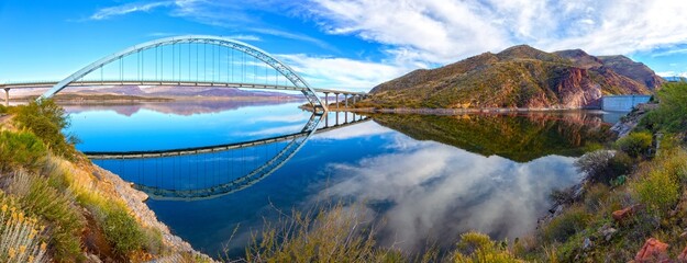 Roosevelt Bridge And Hydroelectric Dam Reflected in Apache Trail Lake Calm Water.  Scenic Superstition Mountains Panoramic Landscape View, Arizona Southwest US
