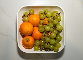 oranges and green grapes on a bowl 